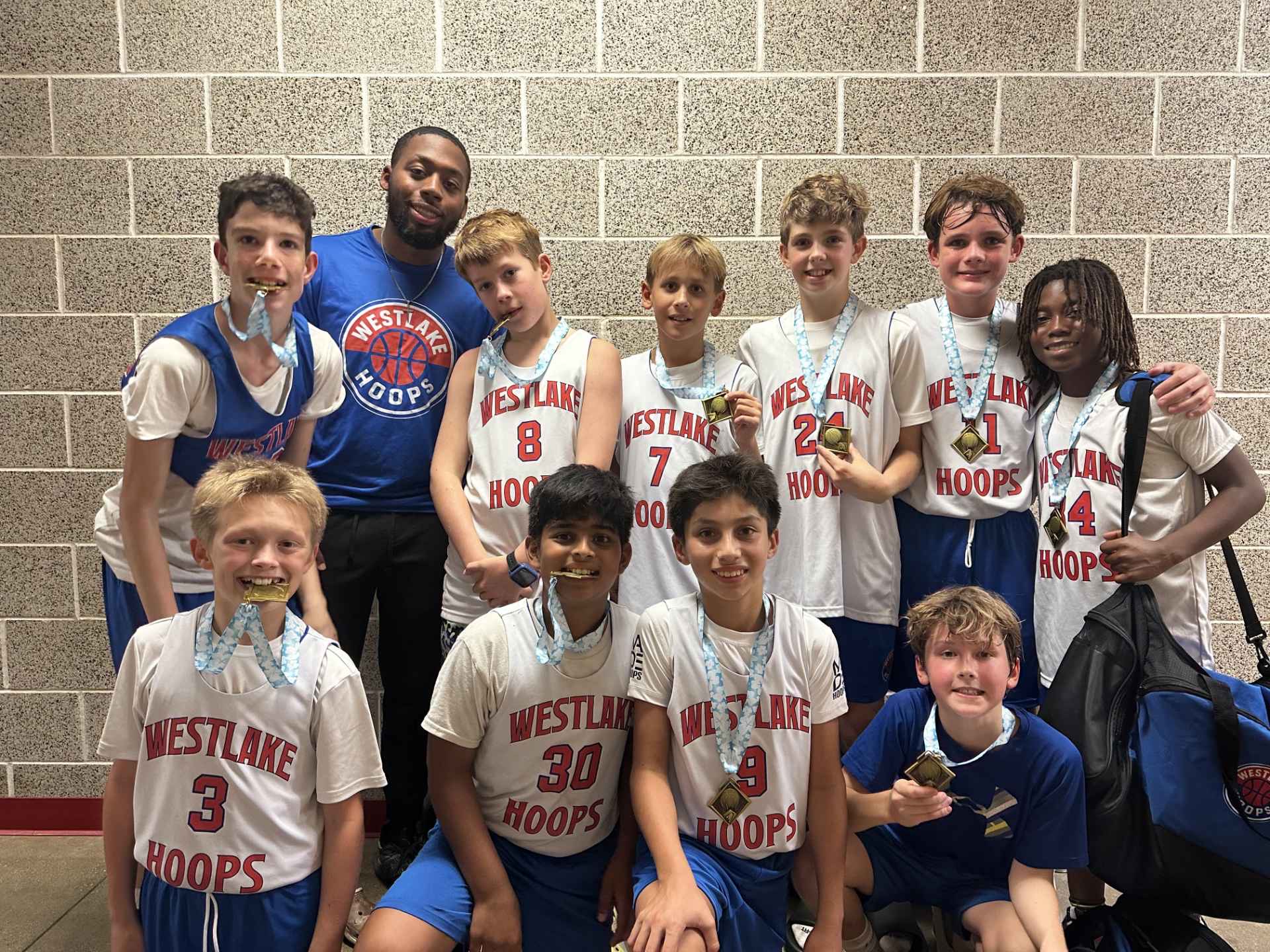 Players with medals and coach after a championship win.