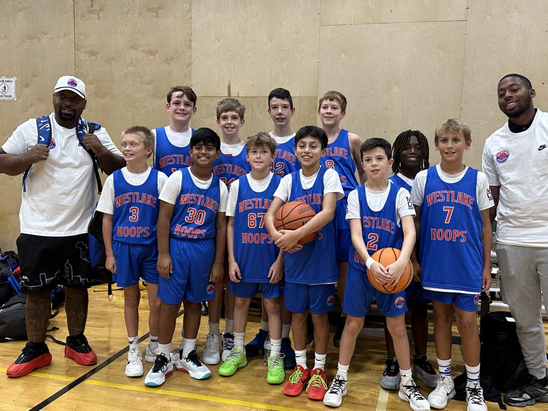 Westlake Hoops Select team posing in the gym after a tournament win.